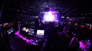 Fisheye photo showing a 270-degree view of DJ performing at the Bomb Factory in Dallas, with video screens, lighting effects, and a crowd engaged in a live Audio Video Experience.