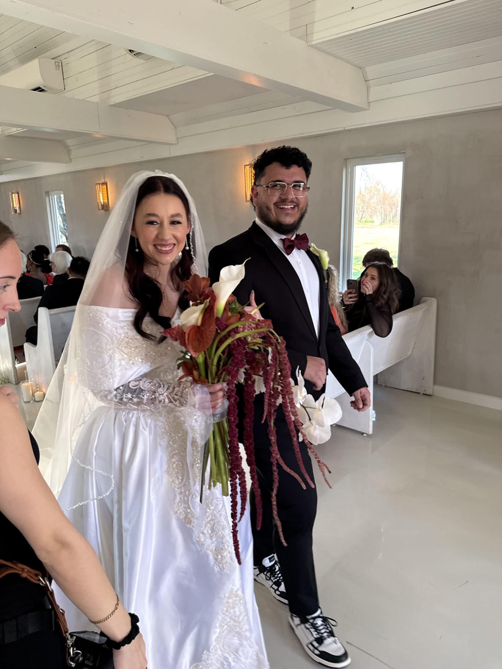 Smiling Latino bride and groom walking down the aisle after their wedding ceremony in Dallas-Fort Worth