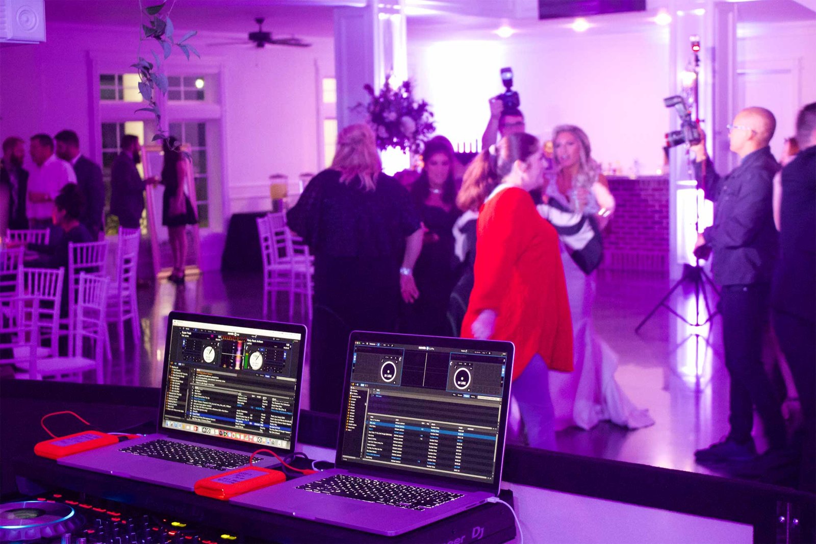 Professional wedding DJ setup with two laptops as the bride and guests dance during a reception at The Springs in Weatherford, Texas.